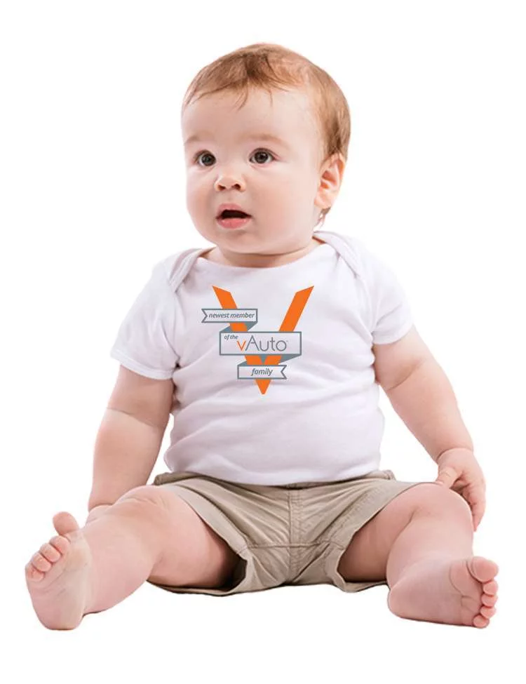 baby seated on the floor and wearing a white shirt with a company logo on the front as a corporate baby gift