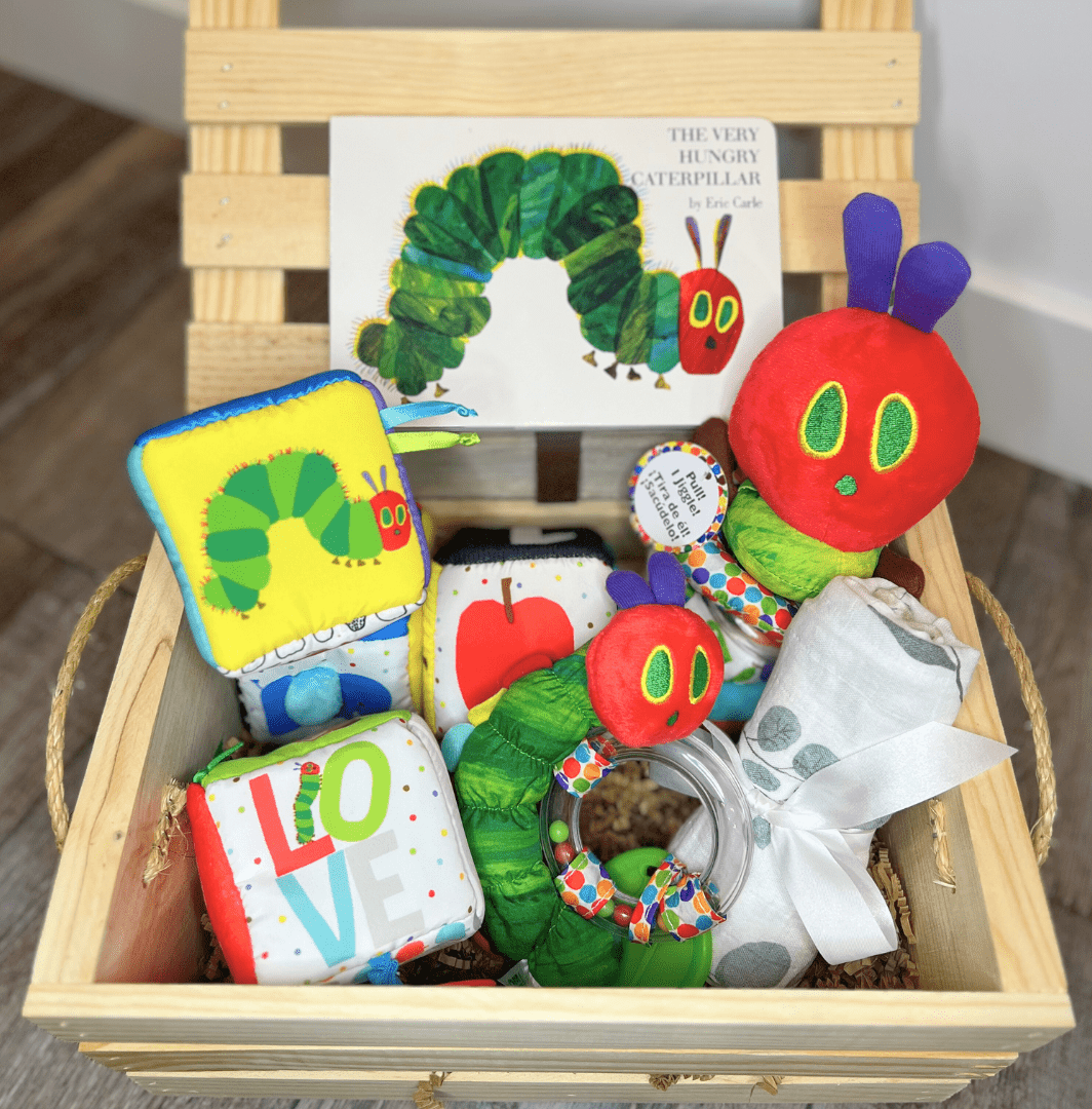 wooden box with the very hungry caterpillar board book and other hungry caterpillar baby toys as a beautiful baby shower gift basket