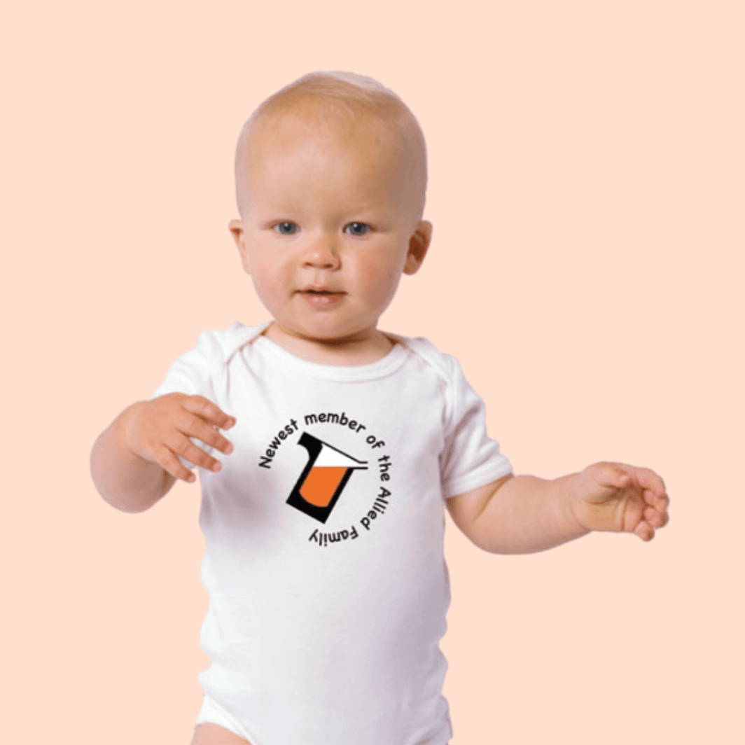corporate baby gift showing small child wearing a white onesie with company logo on it